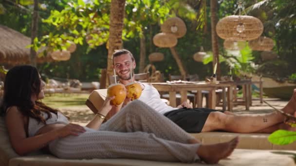 Молода Щаслива Багатоетнічна Пара Відпочиває Шезлонгах Тропічних Курортах Кокосову Воду — стокове відео