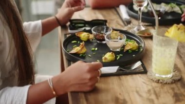 Kadın eli yakınındaki ahşap bir masada siyah bir tabak ve soya sosu. Lokantada servis edilen karanlık sofra takımında servis edilen doğu mutfağı tabağı. Akşam yemeği için geleneksel Asya yemeği. Yiyecek ve içecekler.