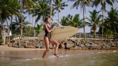 Afrikalı Amerikalı kadın sörf tahtasıyla okyanus suyuna koşuyor, kürek çekiyor. Sörf tahtası olan siyah bir kadın sörfçü. Çok ırklı güzel bir kız güneşli bir yerde sörf yapmaya gidiyor.