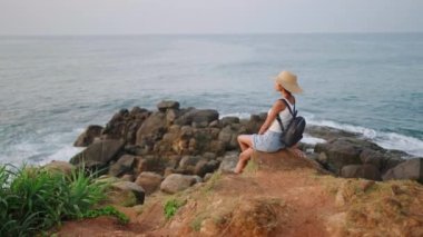 Güzel bir Afrikalı kadın gün doğumunda adada okyanus manzarası seyretmekten hoşlanıyor. Hasır şapkalı melez bir kadın egzotik deniz yolculuğuna çıkıyor. Turist bipoc kızı kayalık bir uçurumda oturup rahatlıyor..