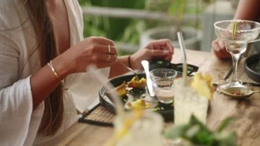 Restoranda çatal ve bıçakla kızarmış wonton yiyen bir kadın. Genç bir bayan arkadaşlarıyla otantik kafede geleneksel gyoza mantı yiyor. Etnik kız doğu mutfağından hoşlanıyor.
