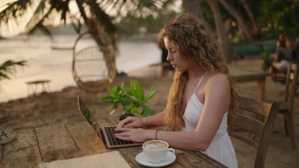Νεαρή Γυναίκα Προγραμματίστρια Που Δουλεύει Λάπτοπ Δίπλα Στον Ωκεανό Ηλιοβασίλεμα — Αρχείο Βίντεο