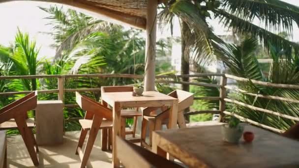 空旷的热带天台餐厅在海边的度假胜地等客人和客户 真正的咖啡馆在异国情调的地方 有木制的椅子和桌子 没有人在阳光灿烂的日子 暑假的概念 — 图库视频影像