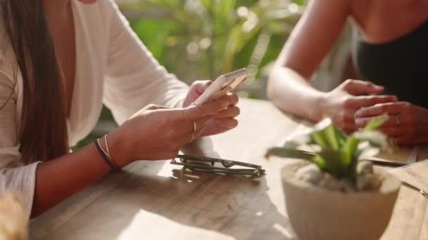 스마트폰을 바닷가 카페에서 스크롤 타이핑을 여성들 식당에서 전화를 사용하는 소녀의 — 비디오