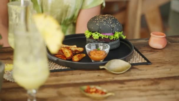 Egy Hamburgerrel Sült Krumplival Előtte Fekete Hamburgert Krumpli Ékekkel Tálalták — Stock videók