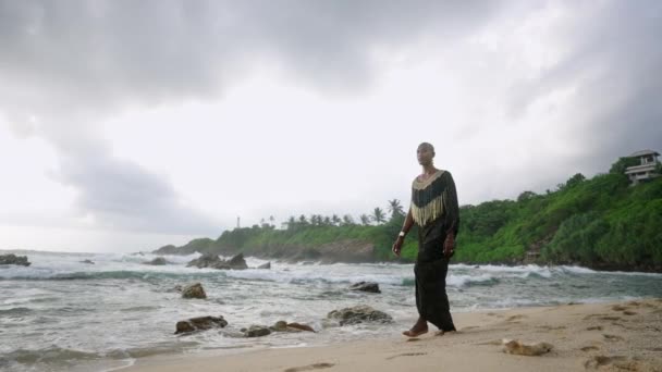 Λοατκια Μαύρος Γυαλιστερό Φόρεμα Περπατάει Στην Εκπληκτική Ακτή Της Θάλασσας — Αρχείο Βίντεο