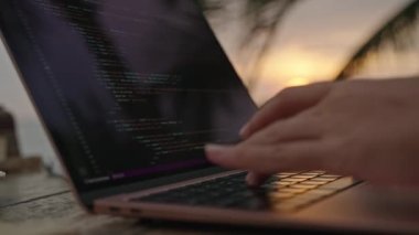 Günbatımında okyanus kenarında dizüstü bilgisayarda çalışan genç bir kadın müteahhit. Açık hava tropikal kafede serbest çalışan bir kadın. Kafkasyalı kız, egzotik mekanlarda bilgisayarını uzaktan kontrol ederek çalışıyor.