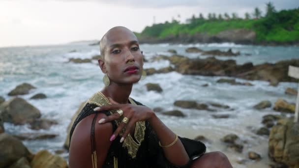 Φανταχτερός Γκέι Μαύρος Πολυτελές Φόρεμα Ποζάρει Στη Βραχώδη Παραλία Του — Αρχείο Βίντεο