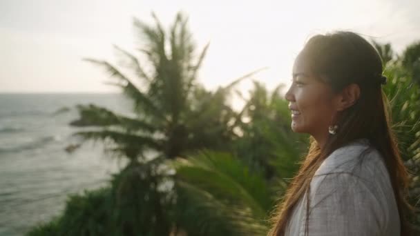 Aziatisch Vrouwtje Een Witte Jurk Kijkend Naar Zee Etnische Jonge — Stockvideo