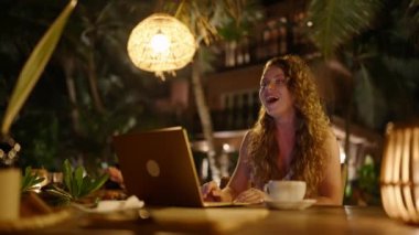 Heyecanlı beyaz kadın bilgisayardan harika olumlu haberler izliyor. Dizüstü bilgisayara bakıp gülümseyen genç bir kadın. İnternetten alışveriş yapan mutlu bir kızın portresi güzel bir şey buluyor.