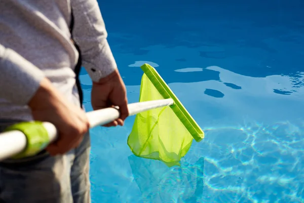 Mand Med Skimmer Net Udstyr Rengøring Swimmingpool Fra Affald Mand - Stock-foto