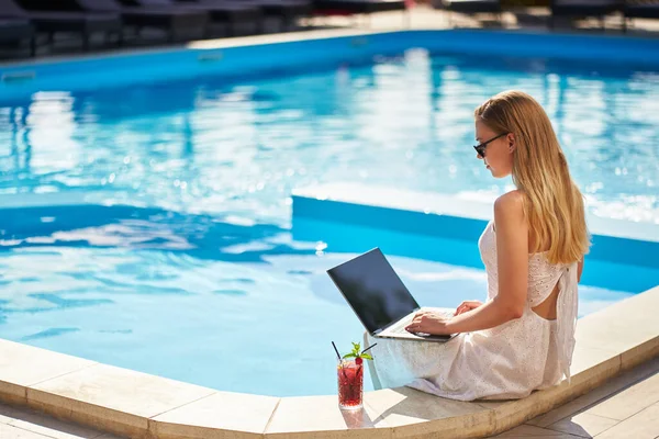 Samozatrudniona Kobieta Wykonująca Pracę Zdalną Laptopem Siedzącym Przy Basenie Tropikalnym Zdjęcie Stockowe