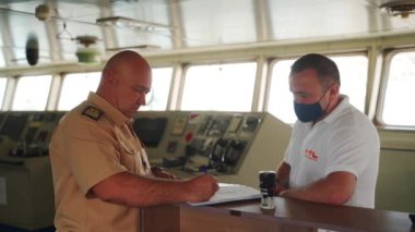 2021-06-09 Mariupol, Ukrayna. Ukrtransagro LLC. Gemi kaptanı ve nakliye acentesi, kargo sözleşmesi ve el sıkışma faturasını damgalayıp imzalayarak anlaşmaya varır. Ulaşım iş anlaşması kavramı