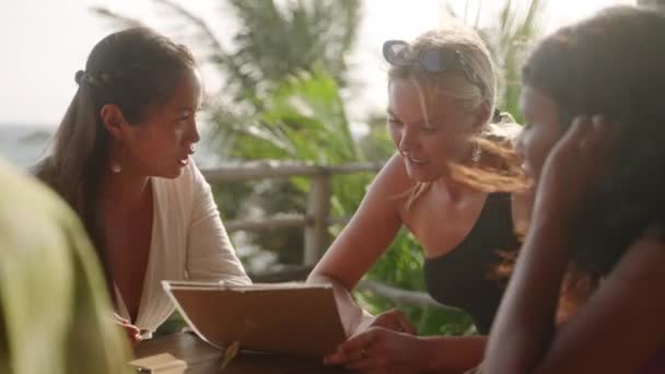 바닷가 식당에 친구들 음료를 마시고 메뉴를 이야기를 나눈다 카페에서 인종으로 — 비디오