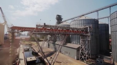 Tahıl, limandaki deniz tahıl terminalindeki yük konteynırına yükleniyor. Buğday sevkiyatı, ambardan büyük bir gemiye, deniz limanındaki sandık yoluyla. Tarım ürünlerinin nakliyesi..