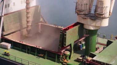 Limandaki deniz tahıl terminalindeki yük konteynırına buğday yükleme. Buğday sevkiyatı, ambardan büyük bir gemiye, deniz limanındaki sandık yoluyla. Tarım ürünlerinin nakliyesi..