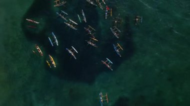Turkuaz bir okyanus sularının ortasındaki renkli otantik balıkçı tekneleri. İHA 'dan alınan deniz görüntülerinin yüzeyinde yüzen Oruwa botları. Yerel balıkçılık endüstrisi