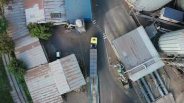 Tahıl kamyonunun ya da tahıl asansörü silolarının endüstriyel alanından geçen çöp kamyonunun üstünden hava görüntüsü. Yol boyunca giden emty body fragmanının üst görüntüsü. Hava aracı helikopter görüntüleri..