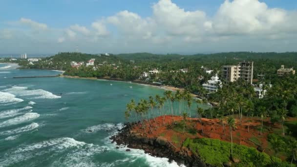 热带岩石岛屿在大海中被海浪冲刷着 斯里兰卡米里萨市著名的具有里程碑意义的Coconut Hill被无人机拍到的海浪冲刷过 海滨度假胜地城镇在海滨俯瞰 — 图库视频影像