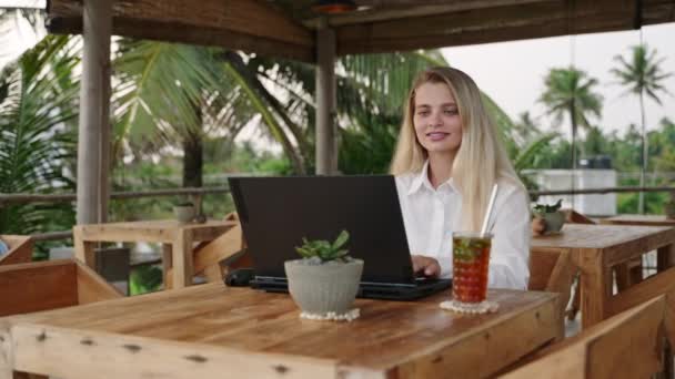 Blondynka Pracująca Laptopem Kawiarni Palmami Kobieta Korzystająca Komputera Zdalnej Pracy — Wideo stockowe