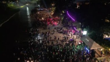 Mirissa, Sri Lanka - 12.31.2022: Plaj gece kulüplerinin hava manzarası. Deniz kenarındaki kafeler ve restoranlar gece renkli ışıklar, deniz kenarındaki kalabalık yeni yıl kutlaması partileri İHA 'nın manzarası altında.