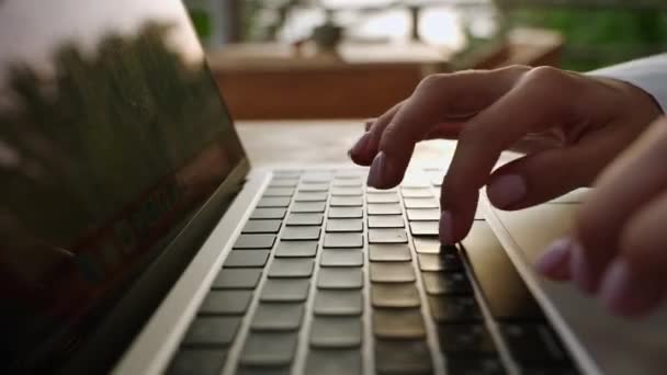 日落时分 一个女人在户外热带咖啡馆的笔记本电脑键盘上打字 人们坐在户外与冰茶合作 用笔记本发短信 在电视上聊天的人写一篇文章的博客 — 图库视频影像