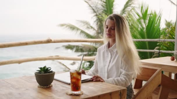 Blondynka Zaczyna Dzień Pracy Otwiera Pokrywę Laptopa Tropikalnej Kawiarni Widokiem — Wideo stockowe