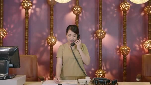 Asiatisk Kvinnlig Receptionist Ett Autentiskt Spa Tar Ett Samtal Ung — Stockvideo