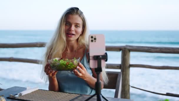 食物博客女性拍摄关于绿色色拉碗的视频 在咖啡馆里节食以适应瘦弱的身体 旅行影响者讲述当地的烹饪 社交网络上的饮食 一只雌鸟拍摄一个Vlog — 图库视频影像