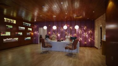 Asyalı spa personeli resepsiyon salonunda selamlıyor. Otel lobisindeki resepsiyonistler merhaba diyor. Lüks sağlık merkezi çalışanları Anjali Mudra namaste pozuyla selamlıyorlar. Taylandlı masöz güzellik kliniğinde kameraya gülümsüyor.