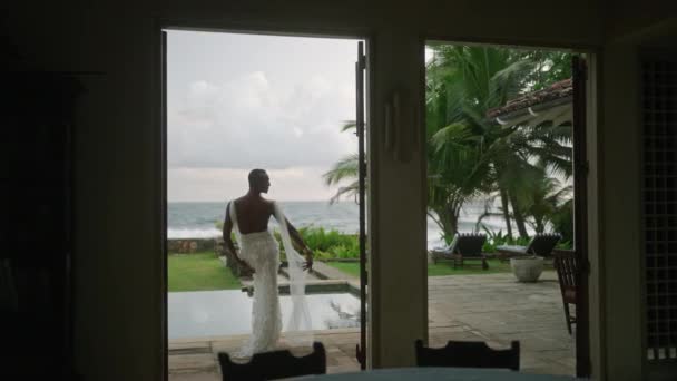 艳丽的黑人男同性恋穿着漂亮的婚纱 穿过豪华别墅 在游泳池边摆姿势 性感的新娘在热带岛屿棕榈树和水边拍摄模特照片 — 图库视频影像