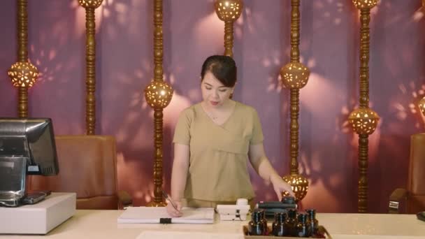 Recepcionista Asiática Auténtico Spa Contesta Teléfono Joven Chica Recepción Multiétnica — Vídeos de Stock