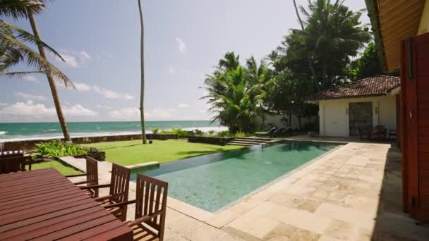 在豪华别墅的游泳池里 白天的热带阳光反射着水面上的光芒 在靠近海洋和棕榈树的度假村的入口处 用日光浴来更新绿松石水 — 图库视频影像