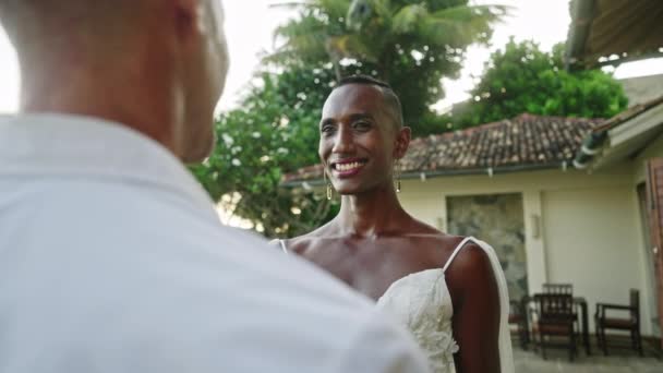 两名多族裔男子在同性合法婚姻派对上调情 非二元新娘 新郎在爱情中凝视 互相微笑 同性恋新婚夫妇在海滩上举行的婚礼热带场地上目不转睛地看着对方 — 图库视频影像