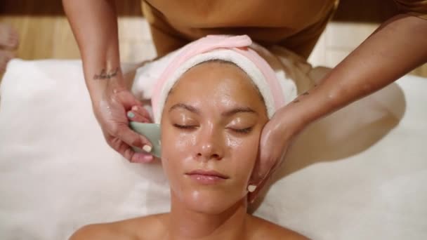 Beyaz Bir Kadın Güzellik Sağlık Merkezinde Gua Sha Aletiyle Yüz — Stok video