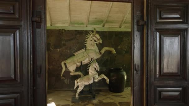 在热带岛屿的豪华复古别墅里 雕塑装饰成两匹白马 在斯里兰卡度假胜地的常绿花园附近 有一个带有木制老式小马雕像的露台 — 图库视频影像