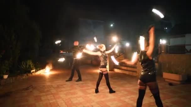 消防表演节目 艺术家们在夜间旋转燃烧的柱子 户外部落与火焰共舞 女舞蹈团在旅游胜地用火把表演 消防队在节日里玩杂耍 — 图库视频影像