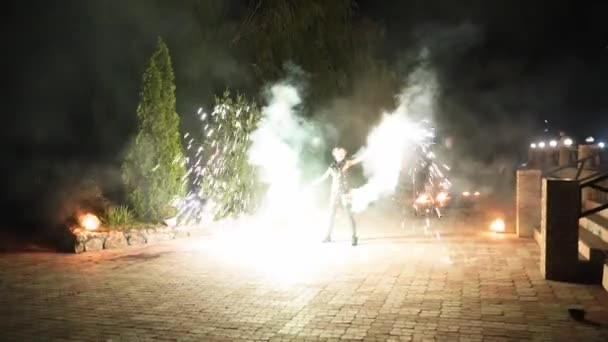 在晚上的火灾现场表演中 精彩的焰火表演 年轻的女艺术家在街上旋转火花 消防员表演惊人的表演 在节日期间与火花在户外嬉戏 — 图库视频影像