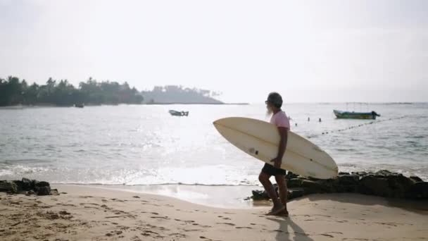 Senior Mannelijke Reiziger Wandelen Een Strand Met Surfplank Heeft Een — Stockvideo