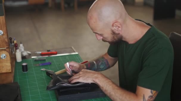 Seitenaufnahme Eines Professionellen Lederhandwerkers Arbeitstisch Der Löcher Eine Schwarze Handtasche — Stockvideo