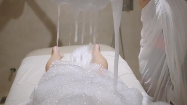 矿泉工在泡沫肥皂泡下给妇女洗澡水 女性放松 在桑拿浴室接受皮肤处理 抗衰老和抗蜂窝药物治疗 — 图库视频影像