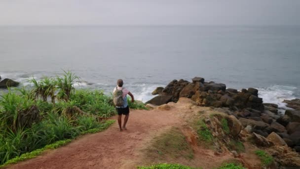 老灰胡子男人背着背包 从热带岛屿上的海角眺望大海 奇异的大自然 老年男子退休后独自旅行 在宁静的地方欣赏风景 — 图库视频影像