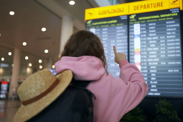 背包客与草帽计分的时间表 节假日开始 机场兴奋 单人观光客探索冬季旅游的选择 图库图片
