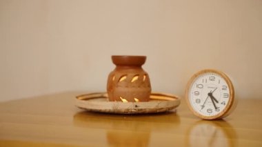 2023-05-18, Colombo, Sri Lanka. Tonik Lanka Spa 'sı. Aroma lambasının yanında saat ve kaplıcadaki bir kavanozda mum. Sürahi ve zaman alarmında dekorasyon yangını. Aromaterapi prosedürü gerekli bir yağ ile..