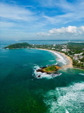 Yarımadanın yukarısında, göz kamaştırıcı körfez manzaralı İHA fotoğrafı, gök mavisi sularda oyulmuş tekneler. Kıyı kasabası yemyeşil, gökyüzünden çekilen manzaralı tropik tatil yerlerinin arasında yer alıyor..