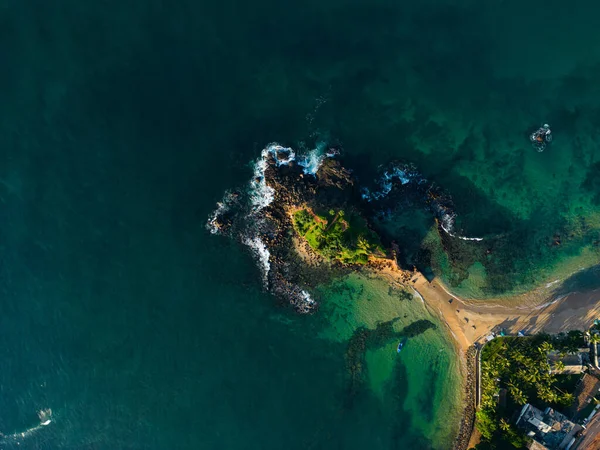 Drone photo of stunning intersection of land and sea, perfect for backgrounds, wall art, and illustrating articles on natures beauty and coastal conservation. Parrot rock island in Sri Lanka.