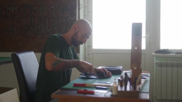 Seitenaufnahme Eines Professionellen Lederhandwerkers Arbeitstisch Der Schnitt Auf Eine Schwarze — Stockvideo
