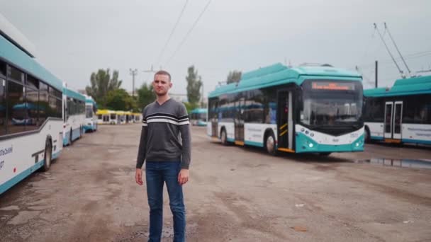 Mladý Profesionální Řidič Silnou Tváří Neformálním Oblečení Stojí Parkovišti Trolejbusu — Stock video