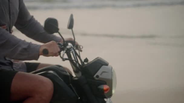 日出时 这对优雅的夫妇骑摩托车沿着海滨散步 内框安装从自行车到人 游客们在海滨驾驶租来的摩托车 女人拥抱着男人 张开双臂骑摩托车 — 图库视频影像
