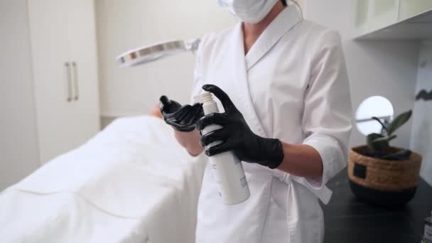 専門家は 麻酔クリニックで手袋された手の製品を適用します 美容師はスパでのフェイシャルトリートメントのためのスキンクレンザーを予防します アンチエイジングプロシージャの準備ができているスキンケアの専門家 クリーン 若返り — ストック動画